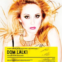 Plakat przedstawiający twarz i ramiona kobiety z długimi, jasnymi włosami i wyraźnym makijażem; w uszach kobiety duże złote kolczyki, a na jej szyi złoty naszyjnik. U dołu zdjęcia informacje o spektaklu.