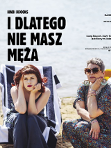 Dwie kobiety - jedna młoda, druga strasza - ubrane w sukienki, siedzą na leżakach na plaży. Obie z poważnymi minami patrzą przed siebie.