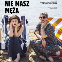 Dwie kobiety - jedna młoda, druga strasza - ubrane w sukienki, siedzą na leżakach na plaży. Obie z poważnymi minami patrzą przed siebie.