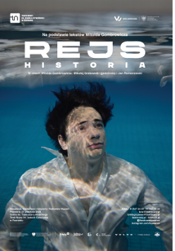 Zdjęcie mężczyzny zanurzonego pod wodą w basenie, ma ciemne włosy, ubrany jest w białą koszulę, patrzy przed siebie