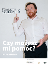 Zdjęcie mężczyzny w białej koszuli na tle białej ściany. Mężczyzna pokazuje palcem napis na ścianie.