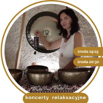 Kobieta w średnim wieku, w białej koszule, z czarnymi kręconymi włosami. Stoi przy rozłozonych złotych misach.