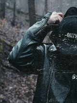 Zdjęcie mężczyzny w skórzanej kurtce i w czapce z daszkiem z napisem "outside". W tle widać las. Z lewej strony żółte stylizowane napisy. Są to szczegóły na temat wydarzenia, zawarte w treści artykułu.