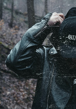 Zdjęcie mężczyzny w skórzanej kurtce i w czapce z daszkiem z napisem "outside". W tle widać las. Z lewej strony żółte stylizowane napisy. Są to szczegóły na temat wydarzenia, zawarte w treści artykułu.