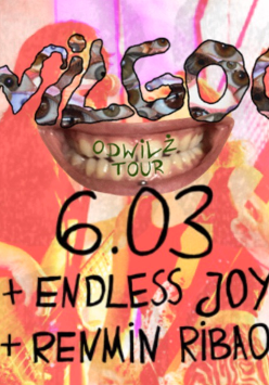 Plakat utrzymany w psychodelicznej estetyce z dominacją różu i czerwieni. W centralnym punkcie znajduje się grafika przedstawiająca szeroko uśmiechnięte usta, nad którymi widnieje napis ułożony z mniejszych elementów tworząc tekst "Wilgoć". Całość jest nałożona na nieostre zdjęcie zespołu muzycznego grającego na instrumentach. Poniżej umieszczono informacje o wydarzeniu zawarte w treści artykułu.