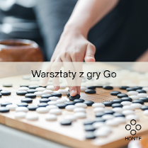 Zbliżenie na planszę do gry Go z czarnymi i białymi kamieniami. Ręka gracza sięga po jeden z nich, a w tle stoi drewniana miseczka na kamienie. Na grafice widoczny jest napis "Warsztaty z gry Go" oraz logo "Honte" z czterema okręgami ułożonymi w romb.