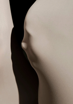 Grafika przedstawiająca dwie jasne płaszczyzny, jedna z zarysem twarzy; między płaszczyznami czarny pas.