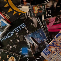 Na zdjęciu znajduje się wiele płyt, kaset i winyli.