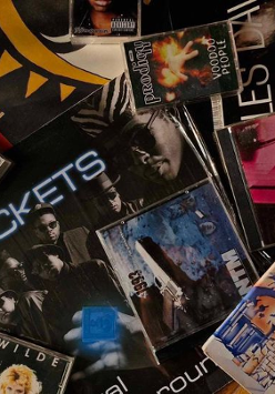 Na zdjęciu znajduje się wiele płyt, kaset i winyli.