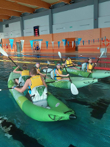 Sześcioro uczestników zajęć w trzech kajakach na basenie.