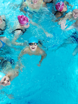 Zdjęcie z lotu ptaka, grupa dzieci bawi się w basenie.