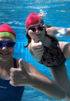 Dziewczynki z kciukiem uniesionym w górę, w basenie.