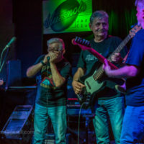 Zdjęcie przedstawiające trzech mężczyzn grających na instrumentach na scenie klubu Blue Note