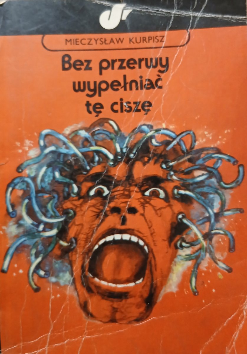 Pomarańczowa okładka książki z grafiką krzyczącej głowy, z której wychodzą kable.