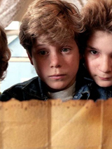 Czterech chłopców trzyma mapę i przygląda się jej z niepokojem.