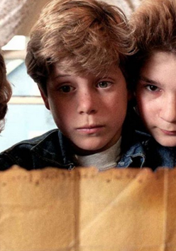 Czterech chłopców trzyma mapę i przygląda się jej z niepokojem.