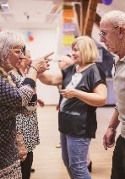 Grupa osób uczestniczących w warsztatach wokalnych.