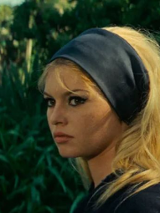 Zdjęcie, tawarz Brigitte Bardot na tle roślin.