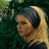 Zdjęcie, tawarz Brigitte Bardot na tle roślin.