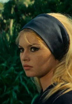 Zdjęcie, tawarz Brigitte Bardot na tle roślin.