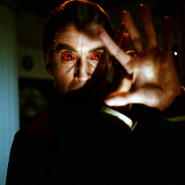 Na fotografii widoczna jest postać, która wygląda przerażająco lub mrocznie. Może to być scena z filmu grozy lub thrillera. Postać ma czerwone oczy, co może być wynikiem użycia specjalnych soczewek kontaktowych, mających na celu stworzenie efektu nadprzyrodzonego lub mistycznego spojrzenia. Oświetlenie i ogólny ton obrazu tworzą atmosferę napięcia i niepokoju, co jest charakterystyczne dla filmów grozy.