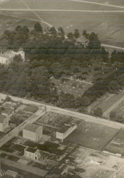 Zdjęcie z lotu ptaka, zabudowania miejskie wśród zieleni.