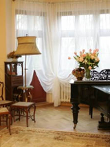 Salon: fortepian, krzesła, lampa