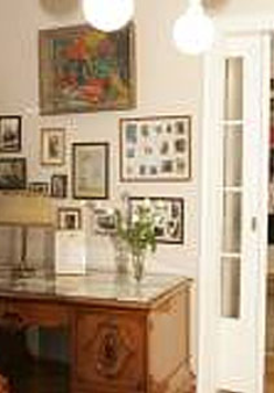 Salon Muzyczny Feliksa Nowowiejskiego: biurki i fotel z epoki, w głebi fortepian