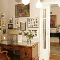 Salon Muzyczny Feliksa Nowowiejskiego: biurki i fotel z epoki, w głebi fortepian