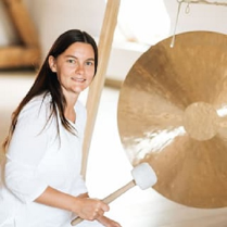 Kobieta uderzająca w gong.