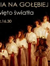 Artyści w długich białych szatach, przepasanych czerwonymi wstążkami, w dłoniach trzymają świeczki. Z boku napisy informujące o wydarzeniu.