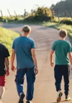 Kadr z filmu "Niech to diabli", cztery osoby, zwrócone do widza plecami idą wiejską drogą.