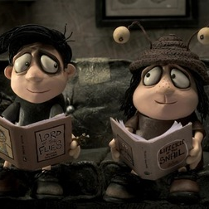 Kadr z filmu Pamiętnik ślimaka, dwie animowane postaci siedzą na kanapie i czytają księżki.