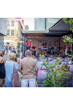Koncert, scena na ul. Quadro, widzowie siedzą na leżakach i stoją