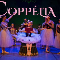 Na scenie dziewczynki przebrane za baletnice. Mają kolorowe gorsety z motywem kwiatowym oraz tiulowe spódnice. W tle zielone tło z napisem "Coppelia".