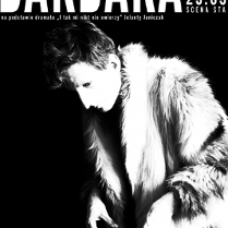 Czarno-białe zdjęcie z wysokim kontrastem. Osoba na zdjęciu ma założone futro, ma krótko obcięte kręcone włosy. Z rękawków wyłaniają się kościste dłonie z długimi, zaniedbanymi paznokciami