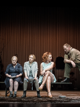 Zdjęcie z przedstawienia - cztery kobiety siedzące na ławce, na skraju ławki mężczyzna, który stoi i jedną nogą opiera się o ławkę.