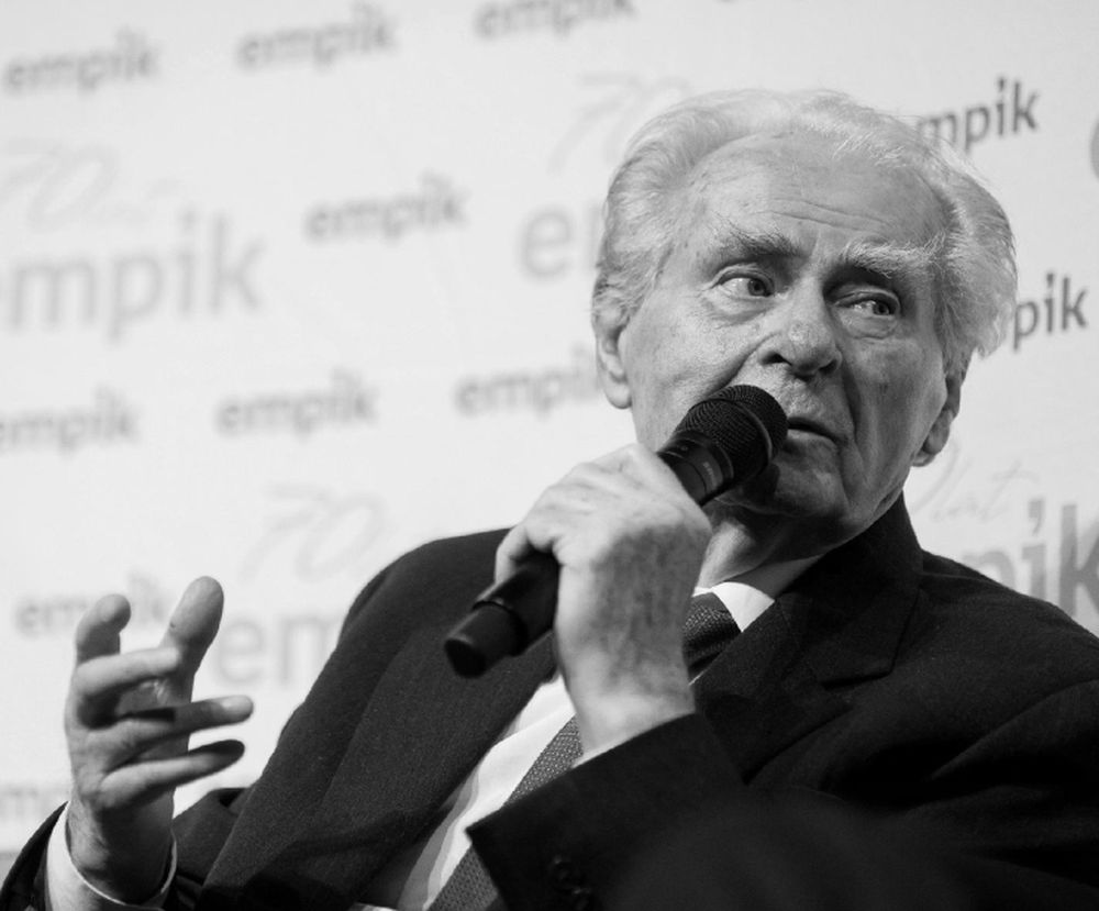 Starszy mężczyzna mówi do mikrofonu na spotkaniu z czytelnikami.