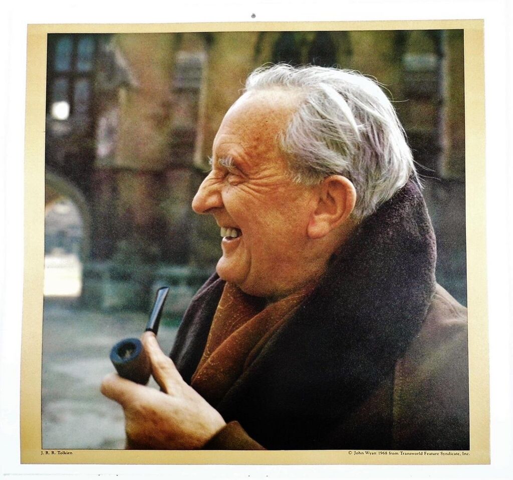 Starszy mężczyzna pali fajkę. Uśmiecha się. Ma zmarszczki koło oczu i łysinę.