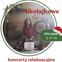 Zdjęcie przedstawia kobietę siedzącą przed dużym gongiem oraz kilkoma misami do śpiewu. Kobieta ma na sobie czerwoną koszulkę. Gong jest zawieszony na suficie za kobietą. Misy do śpiewu są ułożone w półkolu przed nią. Tło stanowi biała ściana. Kobieta ma ciemne włosy i patrzy w obiektyw aparatu. Kobieta lekko się uśmiecha.