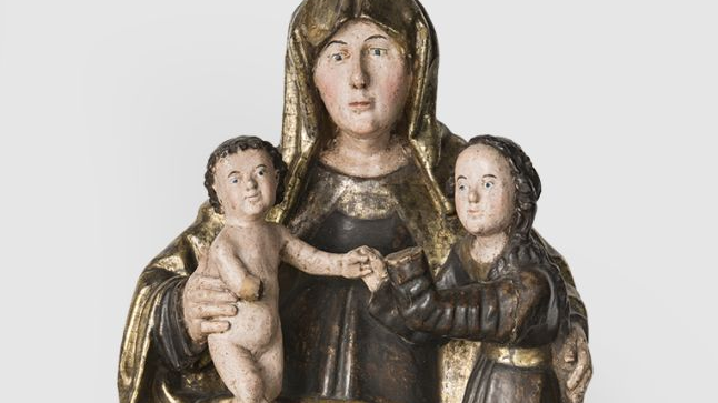Złoto-brązowa rzeźba świętej Anny trzymającej na kolanach dwoje dzieci.
