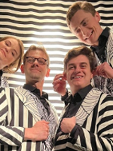 Zdjęcie aktorów we frakach w biało-czarne pasy.