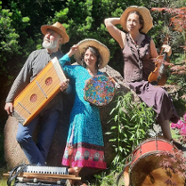 Mężczyzna i kobiety w średnim wieku ubrani w kolorowe stroje. Na głowach mają słomkowe kapelusze a w rękach trzymają różne instrumenty muzyczne. Przed nimi leżą inne instrmenty. Za nimi drzewa i kolorowe kwiaty.