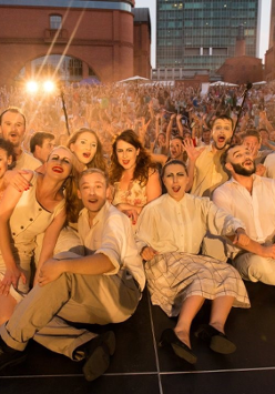 Grupa teatralna ubrana w kostiumy sceniczne pozuje do zdjęcia razem z widownią.