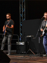 Muzycy z gitarami na scenie