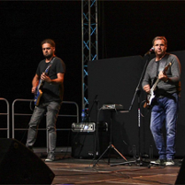 Muzycy z gitarami na scenie