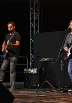 Muzycy z gitarami na scenie