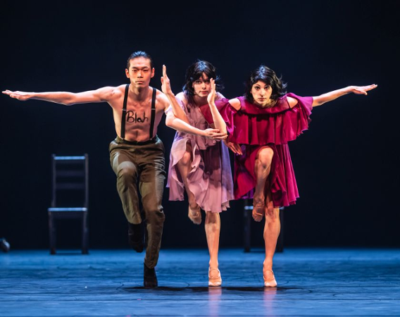 Troje tancerzy na scenie w synchronicznym ruchu.