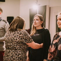 Grupa osób, która bierze udział w warsztatch pracy z głosem.