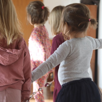 Tańczące dzieci odwrócone tyłem do kamery.